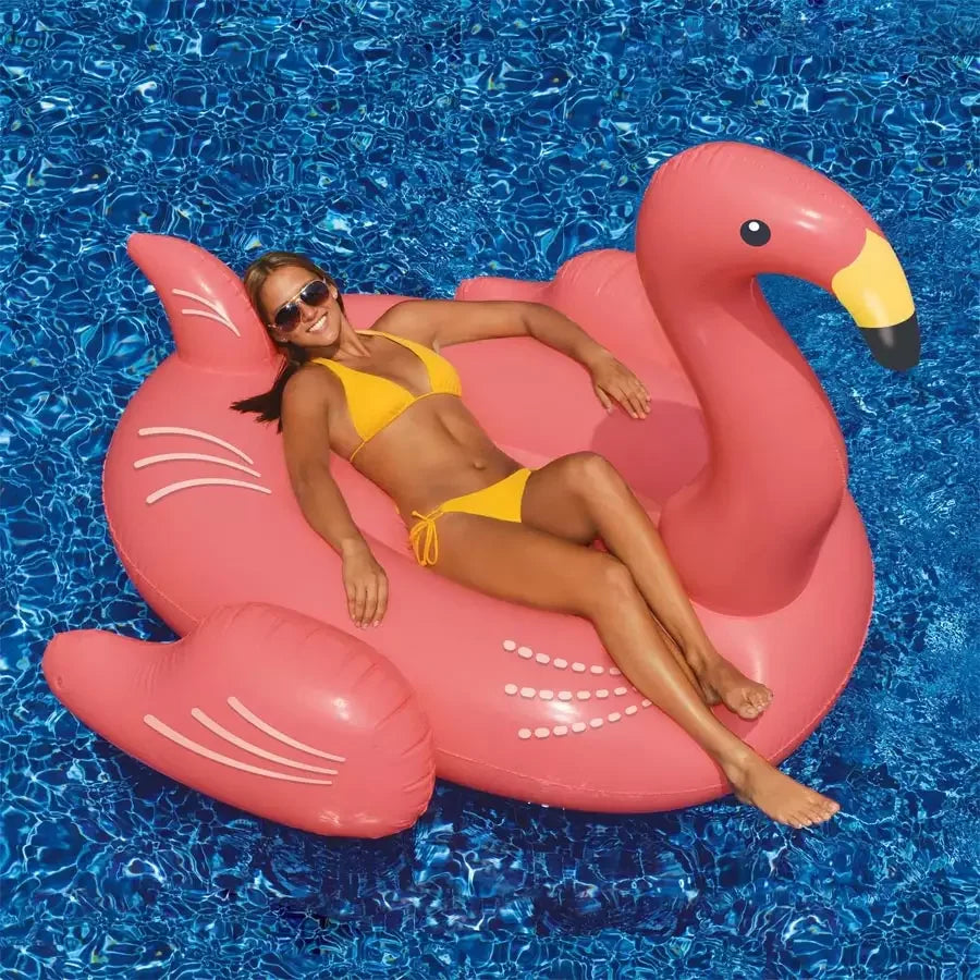 Femme en maillot jaune sur bouée flamant rose dans une piscine bleue