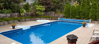 Piscine creusée bleue avec spa, aménagement paysager et terrasse extérieure à Blainville