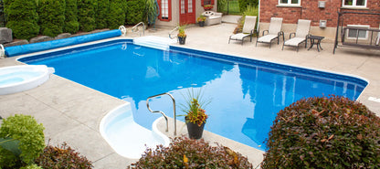Piscine creusée extérieure avec terrasse en béton, chaises longues et spa attenant
