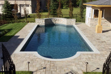 Piscine creusée moderne avec margelle en pierre et terrasse pavée dans un jardin résidentiel
