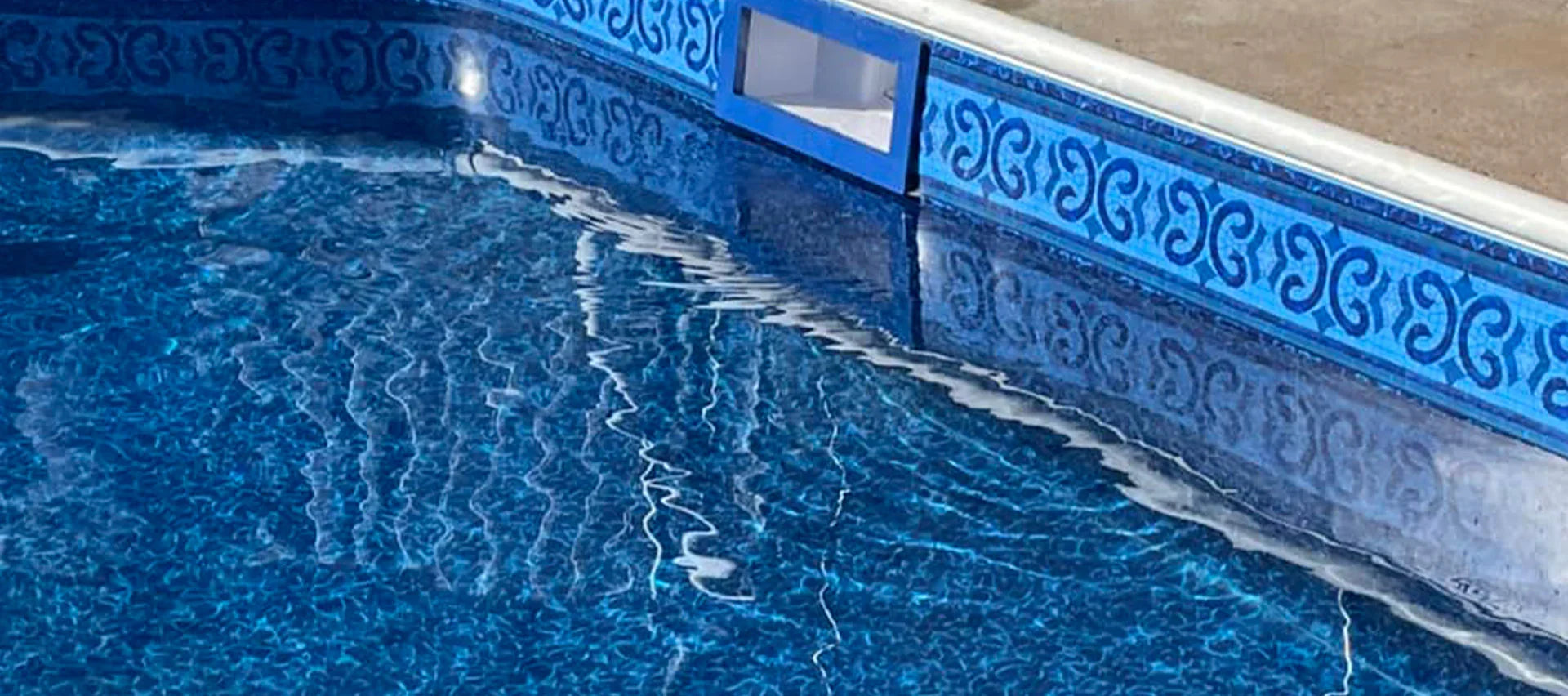 Liner de piscine bleu motif géométrique, surface d'eau claire, margelle en béton