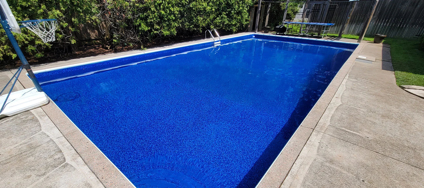 Piscine creusée extérieure avec revêtement bleu, terrasse en béton et panier de basketball