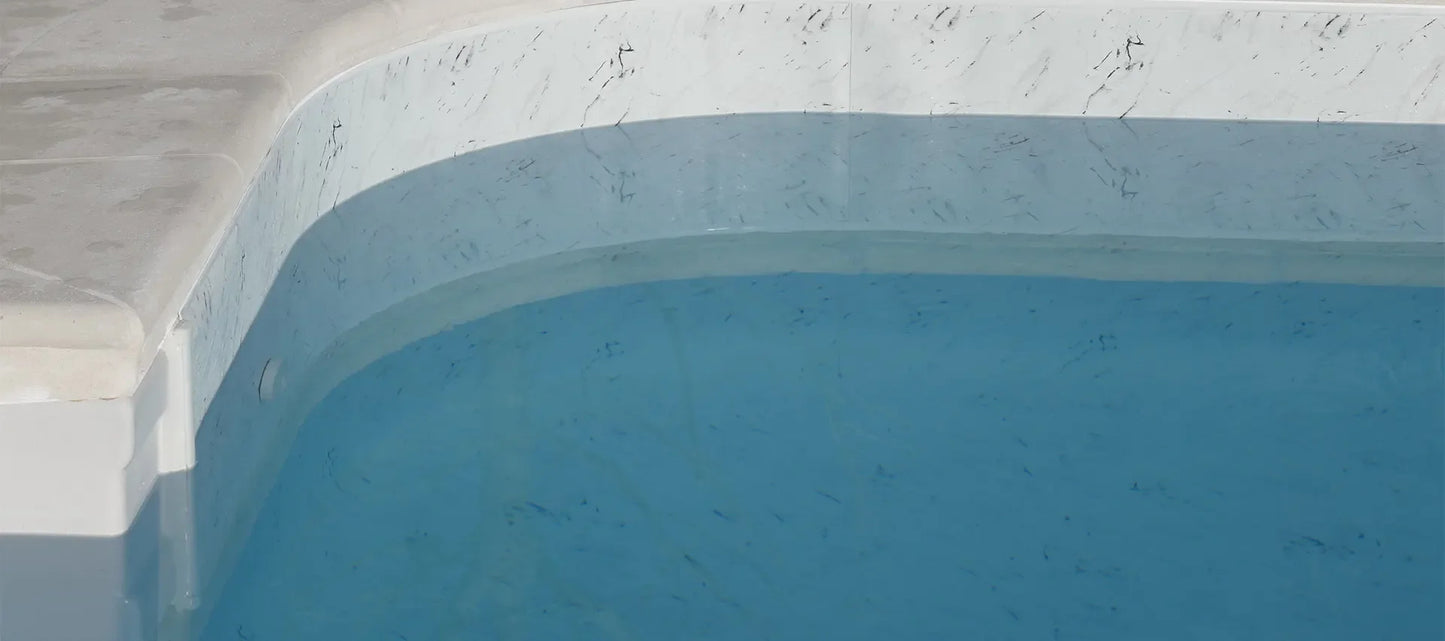 Angle de piscine avec revêtement effet marbre Calacatta et eau claire, design moderne