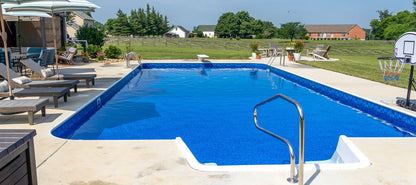 Piscine extérieure rectangulaire avec chaises longues, parasols et panier de basket