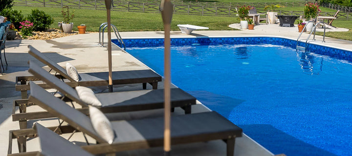 Piscine creusée extérieure avec transats, terrasse et jardin verdoyant, espace détente