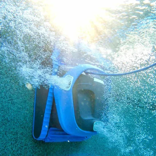 Robot nettoyeur de piscine bleu en action sous l’eau, bulles et lumière solaire